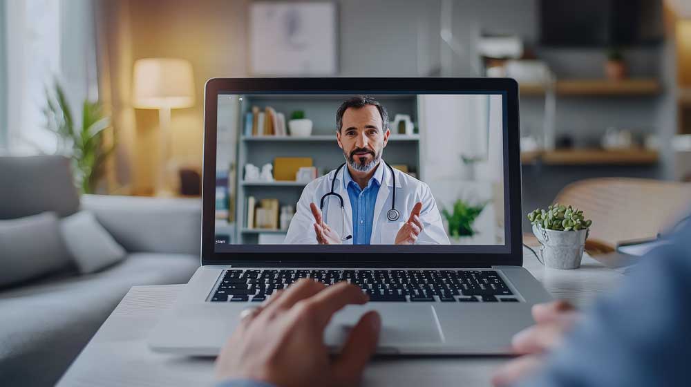 Computer with doctor on screen wearing white coat and stethoscope