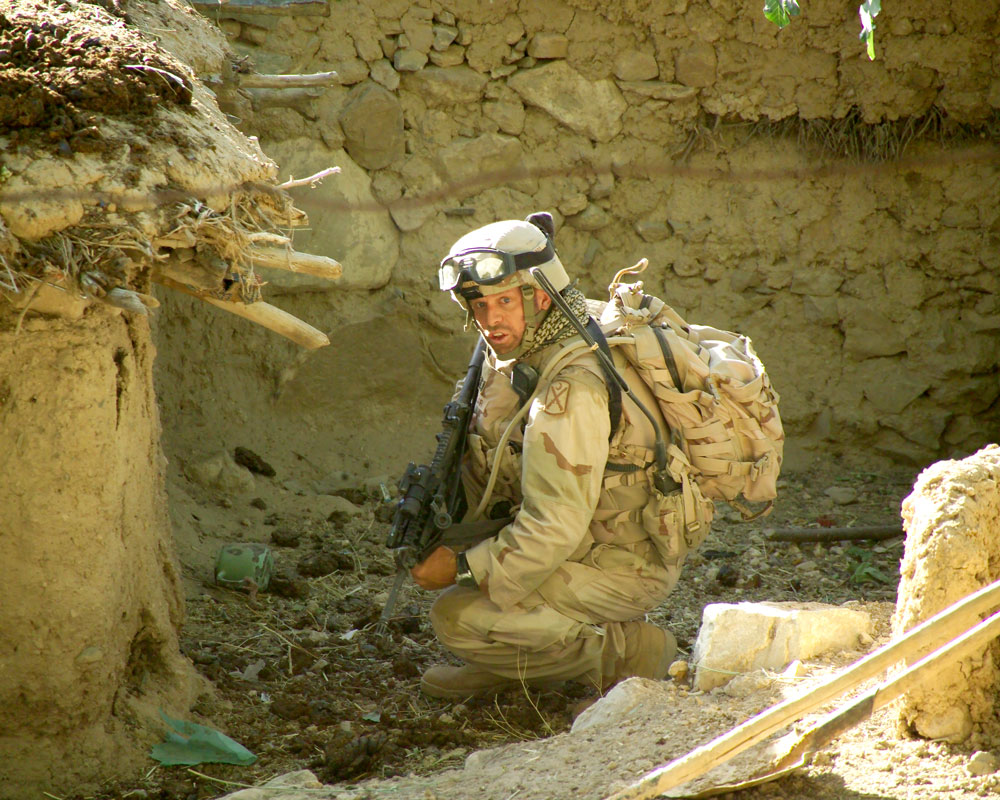 man in camo crouching
