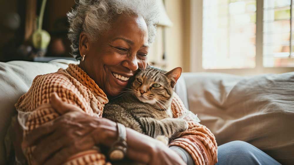 Woman holds cat near face 