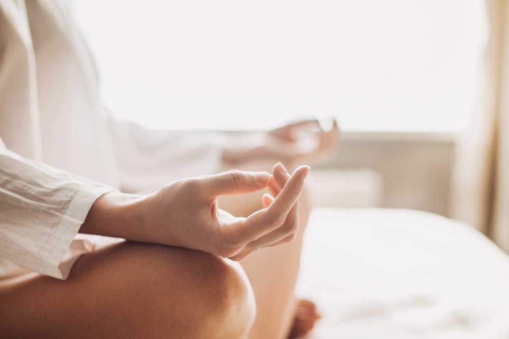 person sitting cross legged meditating 