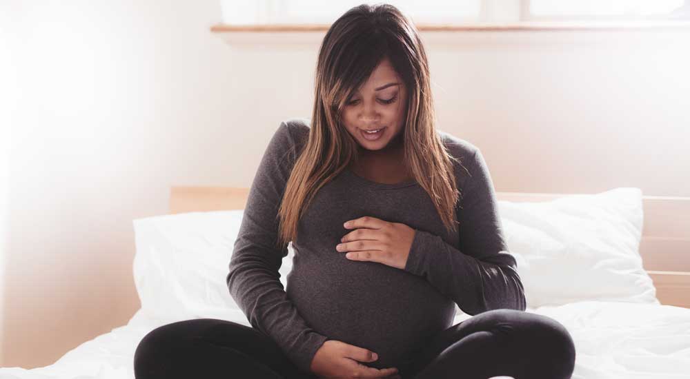 pregnant woman holds belly